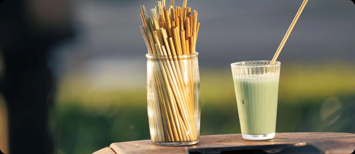 Un verre et un bocale de pailles sur une table